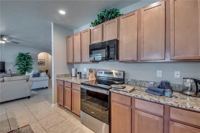 kitchen featuring light tile patterned floors, electric range, light stone counters, and ceiling fan