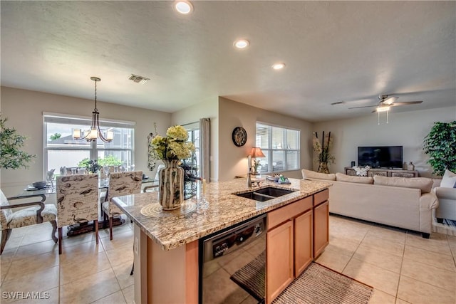 kitchen featuring ceiling fan with notable chandelier, sink, dishwasher, hanging light fixtures, and an island with sink