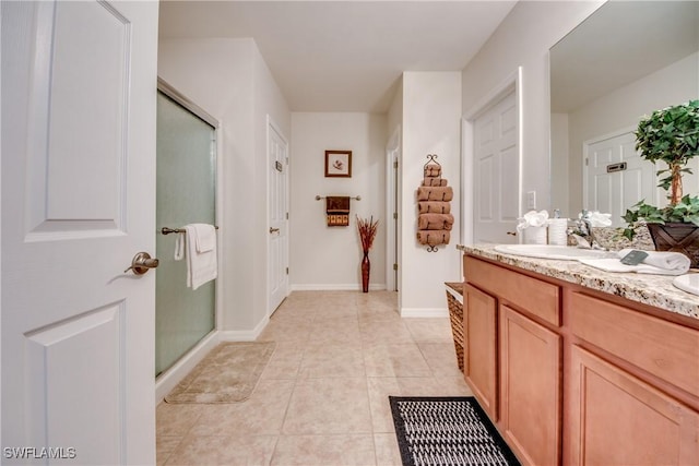 bathroom with tile patterned floors, vanity, and a shower with door