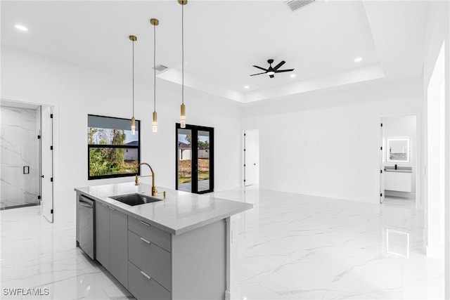 kitchen featuring stainless steel dishwasher, gray cabinets, a raised ceiling, and sink