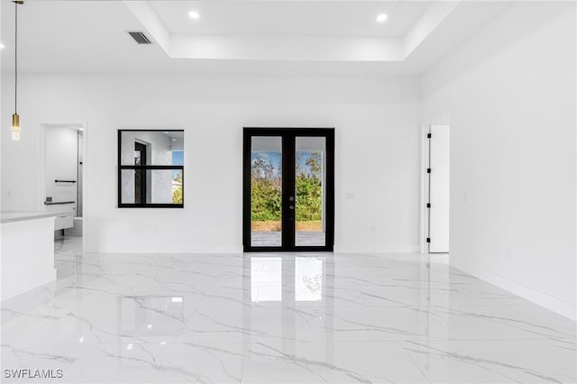 unfurnished room with a raised ceiling and french doors