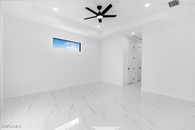 empty room with a tray ceiling and ceiling fan