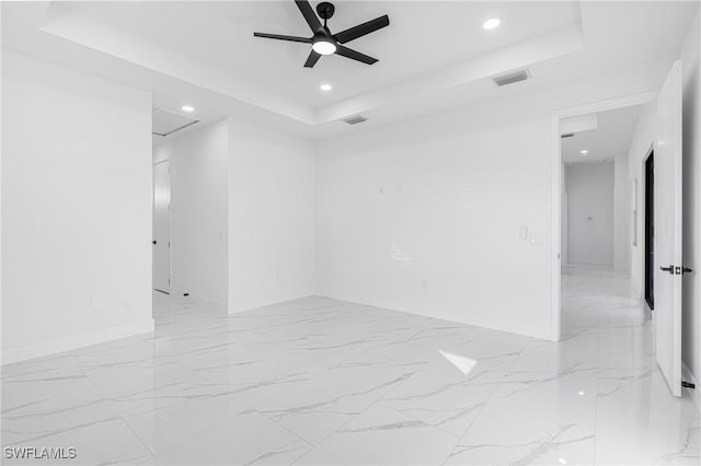 unfurnished room featuring a tray ceiling and ceiling fan