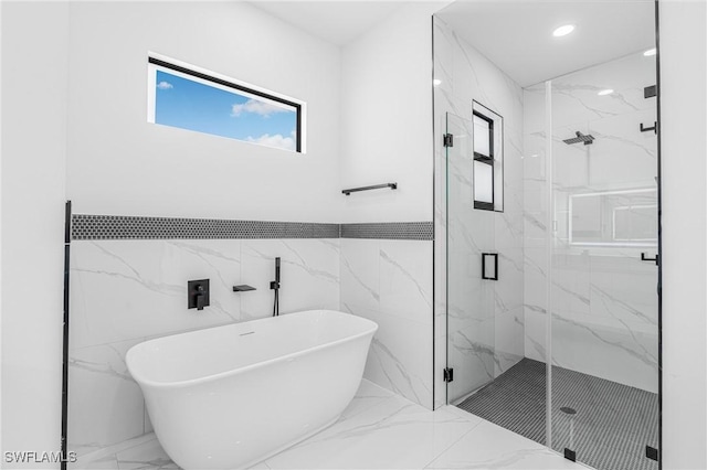 bathroom with separate shower and tub and tile walls