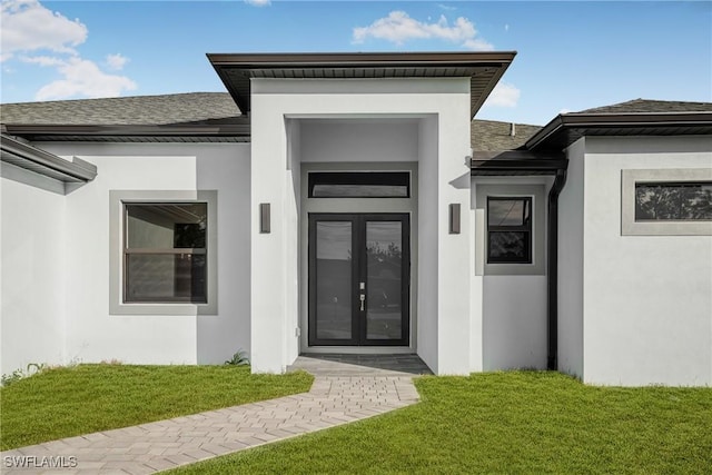 doorway to property featuring french doors and a lawn