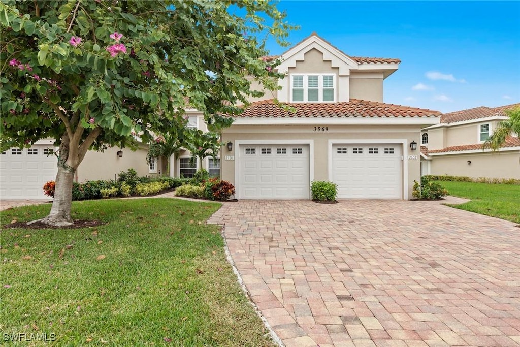 mediterranean / spanish-style house featuring a front yard and a garage