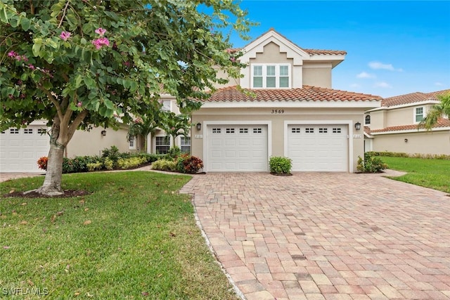 mediterranean / spanish-style house featuring a front yard and a garage