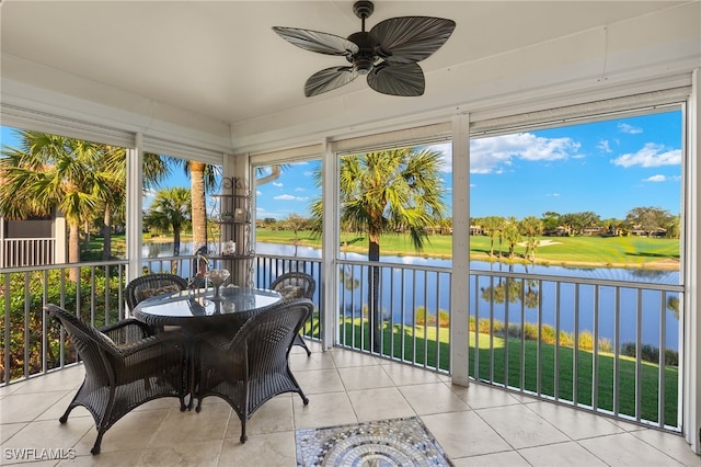 sunroom featuring ceiling fan and a water view