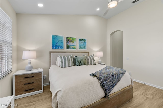 bedroom featuring ceiling fan, light wood-type flooring, and vaulted ceiling