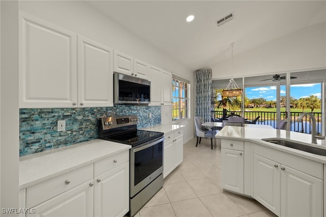 kitchen featuring white cabinetry, sink, stainless steel appliances, and vaulted ceiling