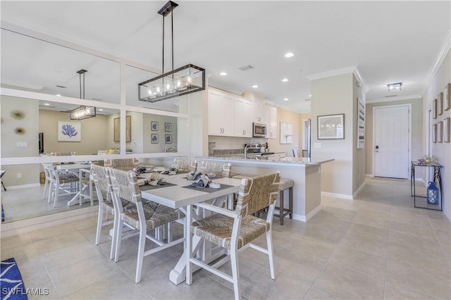 tiled dining area featuring crown molding