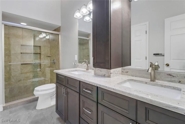 bathroom with vanity, a shower with door, and toilet