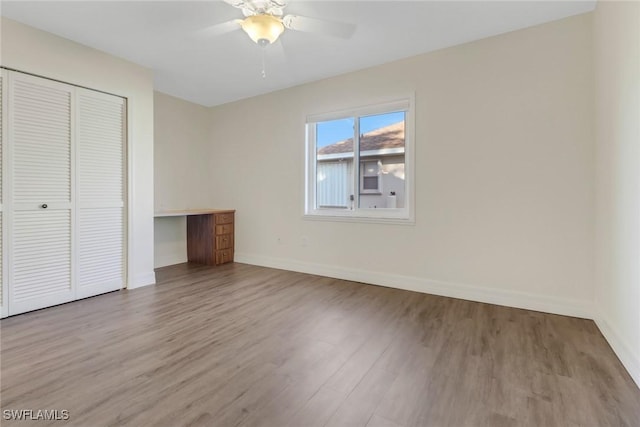 unfurnished bedroom with light wood-type flooring, a closet, and ceiling fan