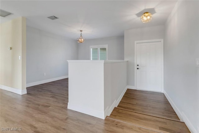 foyer entrance with hardwood / wood-style flooring and a chandelier