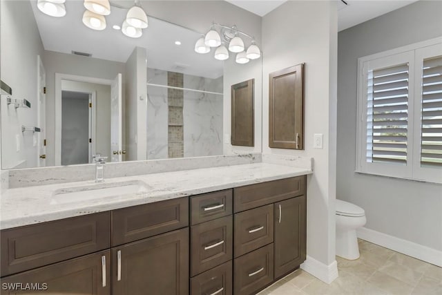 bathroom featuring vanity, tiled shower, and toilet