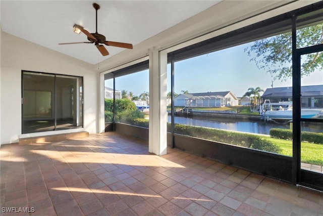 unfurnished sunroom with a water view, lofted ceiling, and ceiling fan