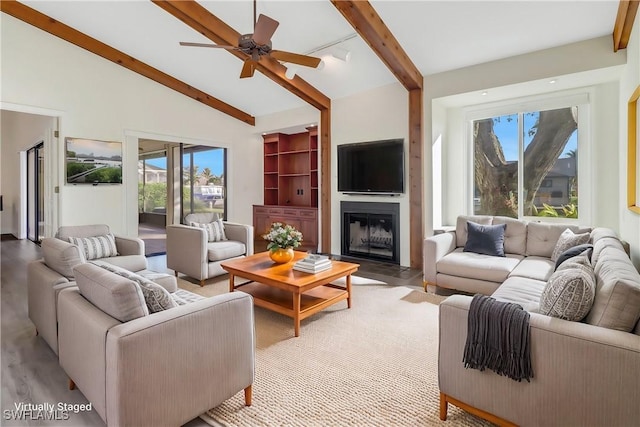 living room featuring light hardwood / wood-style flooring, ceiling fan, and lofted ceiling with beams