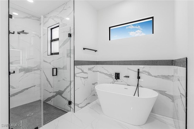 bathroom with tile walls and independent shower and bath