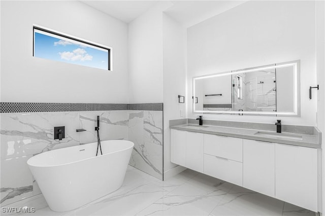 bathroom with vanity, tile walls, and a bathing tub