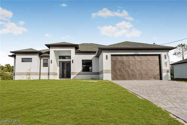 prairie-style home with a front lawn and a garage