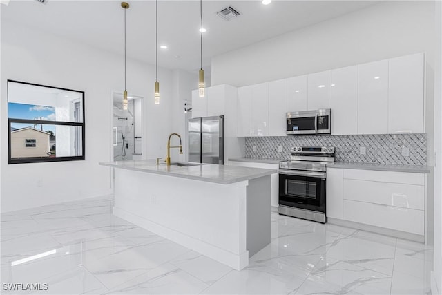 kitchen featuring sink, white cabinetry, hanging light fixtures, and appliances with stainless steel finishes