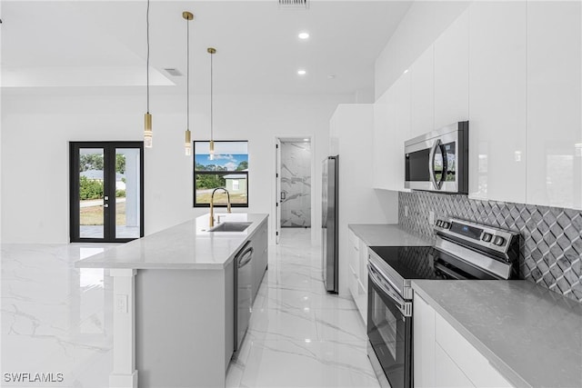 kitchen with sink, white cabinets, decorative light fixtures, and appliances with stainless steel finishes