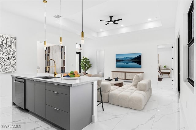 kitchen featuring sink, a raised ceiling, stainless steel dishwasher, pendant lighting, and gray cabinets