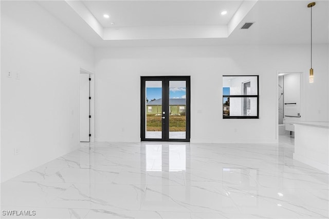 empty room with a tray ceiling and french doors