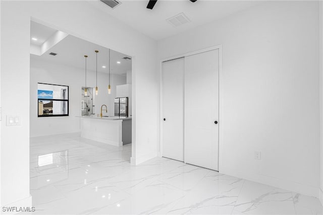 interior space with ceiling fan, sink, and a closet