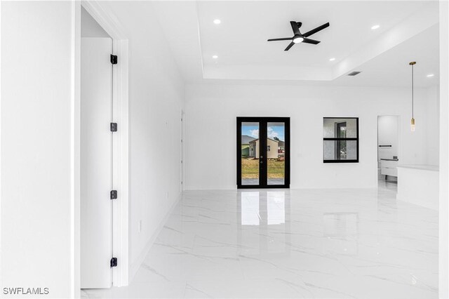 empty room with a tray ceiling and ceiling fan