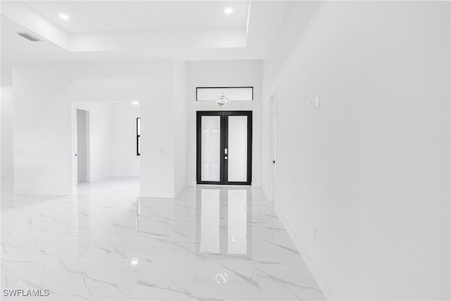 foyer entrance featuring a raised ceiling and french doors