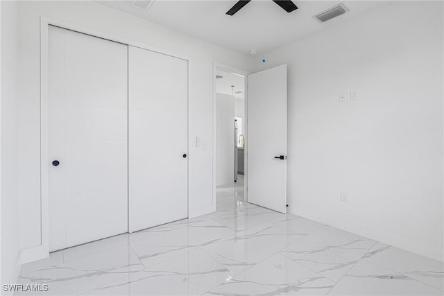 unfurnished bedroom with ceiling fan and a closet