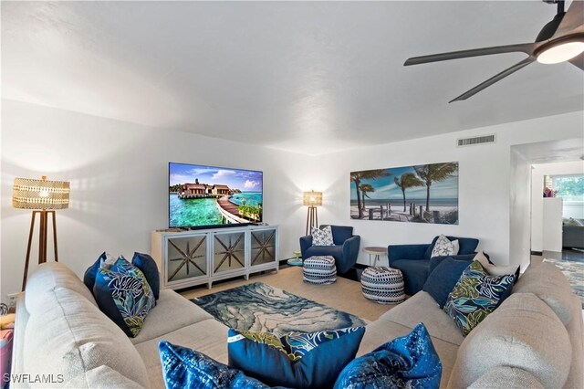 living room with ceiling fan and carpet