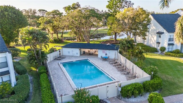 view of pool featuring a patio and a yard