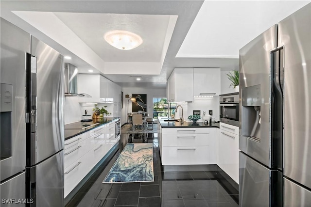 kitchen featuring sink, white cabinetry, a tray ceiling, dark tile patterned flooring, and stainless steel appliances