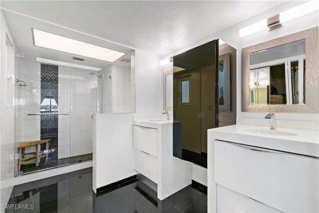 bathroom with tile patterned flooring, vanity, and walk in shower