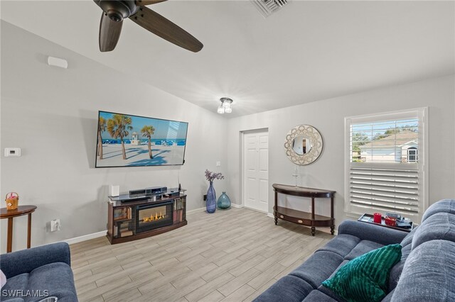 living room featuring vaulted ceiling, ceiling fan, and light hardwood / wood-style flooring