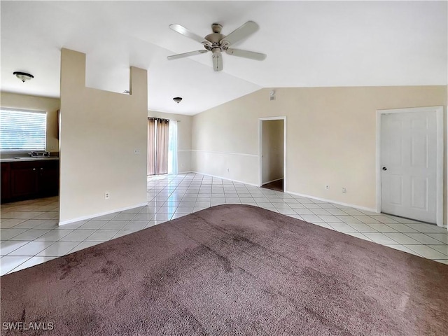 unfurnished room with ceiling fan, sink, light tile patterned floors, and lofted ceiling