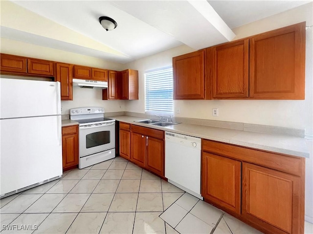 kitchen with lofted ceiling, light tile patterned flooring, white appliances, and sink