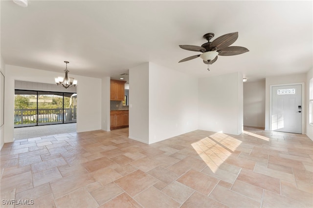 unfurnished living room with ceiling fan with notable chandelier