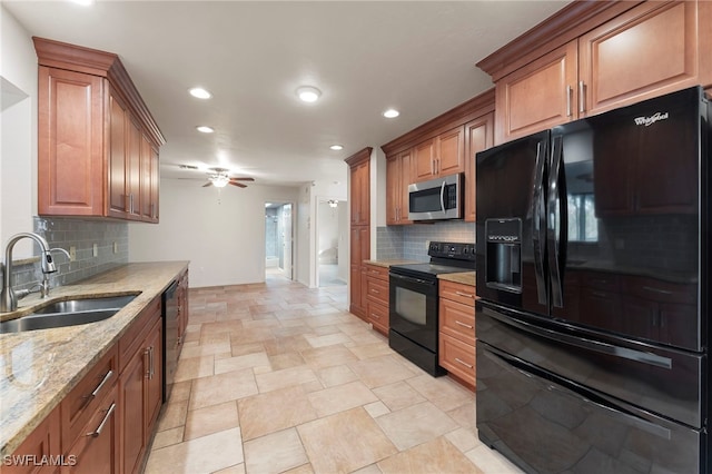 kitchen featuring black appliances, sink, ceiling fan, light stone countertops, and tasteful backsplash