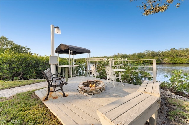 deck with a water view and an outdoor fire pit