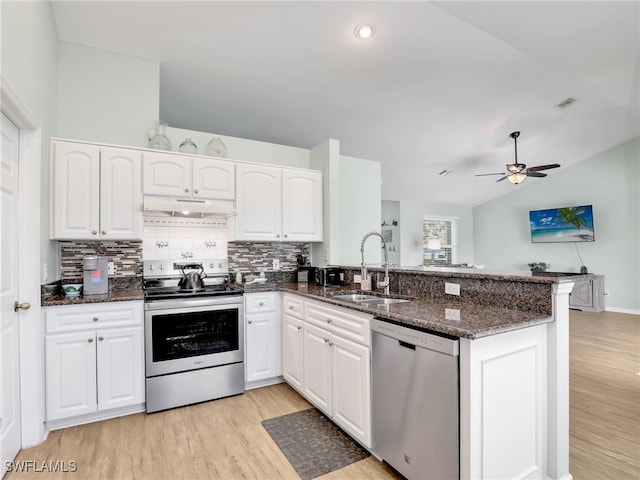 kitchen featuring kitchen peninsula, dark stone countertops, white cabinetry, and stainless steel appliances