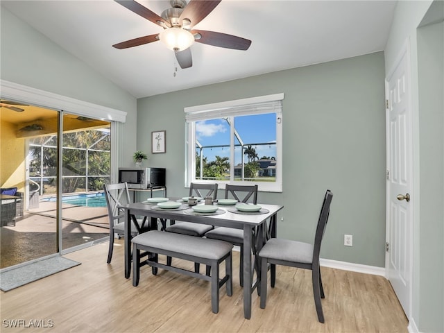 dining space featuring ceiling fan, light hardwood / wood-style floors, and vaulted ceiling