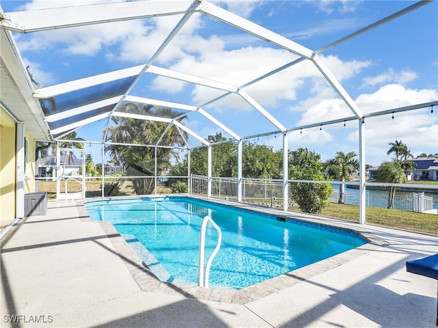 view of swimming pool with a lanai, a patio area, and a water view