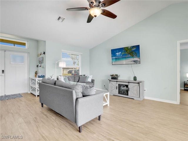 living room featuring ceiling fan, vaulted ceiling, and light hardwood / wood-style flooring