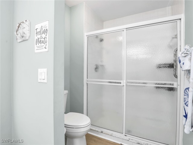 bathroom with walk in shower, hardwood / wood-style flooring, and toilet