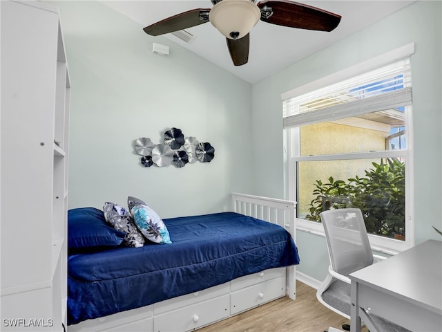 bedroom featuring ceiling fan, light hardwood / wood-style floors, and multiple windows