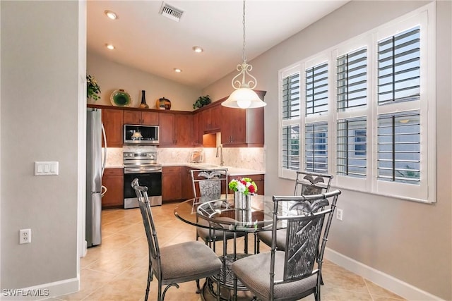 dining room with light tile patterned flooring and lofted ceiling