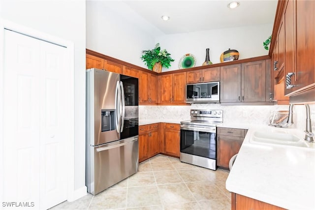 kitchen with decorative backsplash, appliances with stainless steel finishes, light tile patterned flooring, and sink